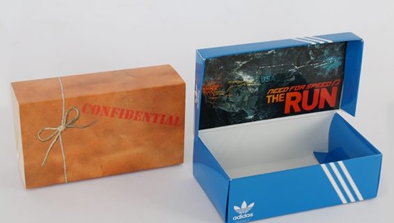 A closed promotional box on the left with the word Confidential on the front and the same box opened to reveal an Adidas promotional shoebox on the right