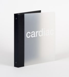 A close up of a light grey binder with a black back binding and the word cardiac across the front