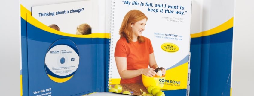 Blue, yellow and white binder with a dvd holder, a folder for a pamphlet and an informational booklet