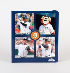 Promotional binder, blue with the Detroit Tigers logo in orange in the center and three baseball players and Paws the mascot around it