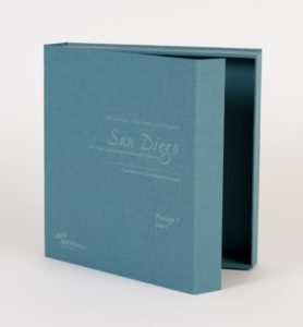 Dark teal colored binder box with magnetic closure and white elegant style writing on the front