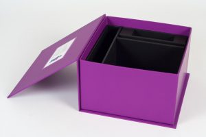 Dark purple turned edge magnet box opened to show a custom interior with inserts for products and other informational materials