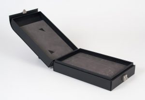 Opened black turned edge box with grey protective cushion on the inside and a silver clasp