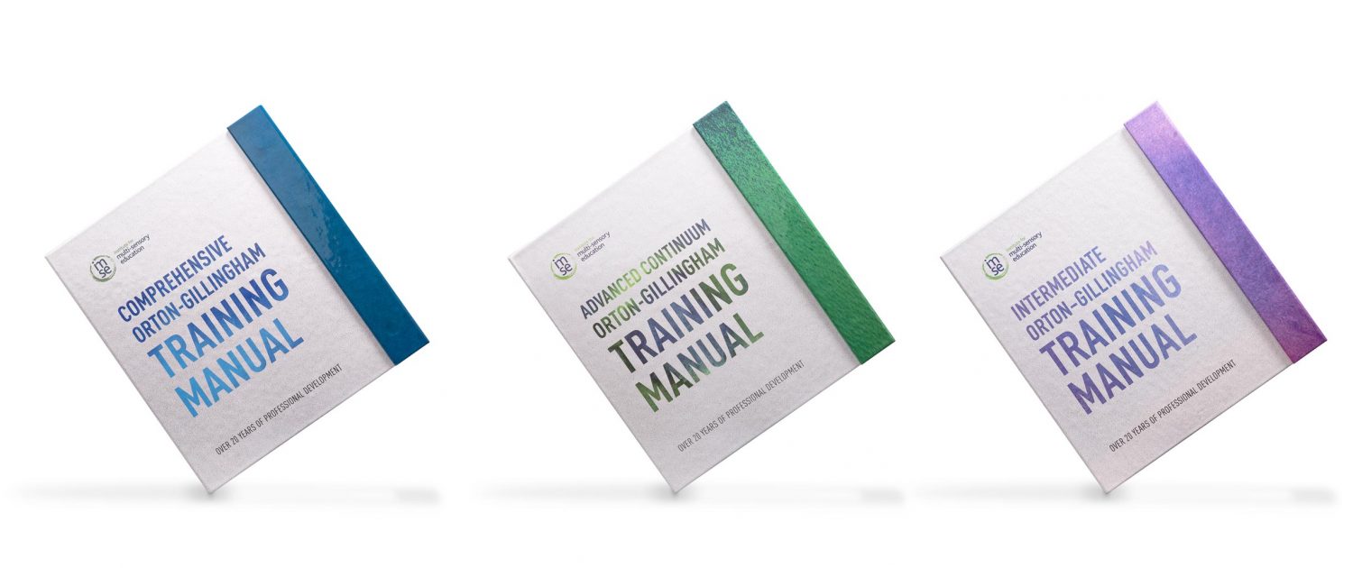 Row of three custom turned edge training manuals, one blue, one green and another purple
