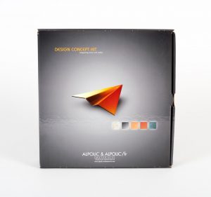 Dark grey product mailer box standing up with orange paper airplane on the front