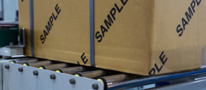 box labeled with sample on a conveyor belt