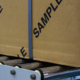 box labeled with sample on a conveyor belt
