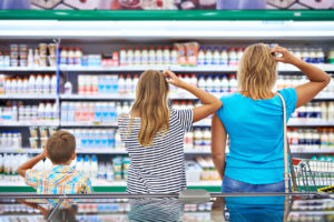 Mother and children are choosing dairy products in shop