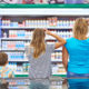 Mother and children are choosing dairy products in shop